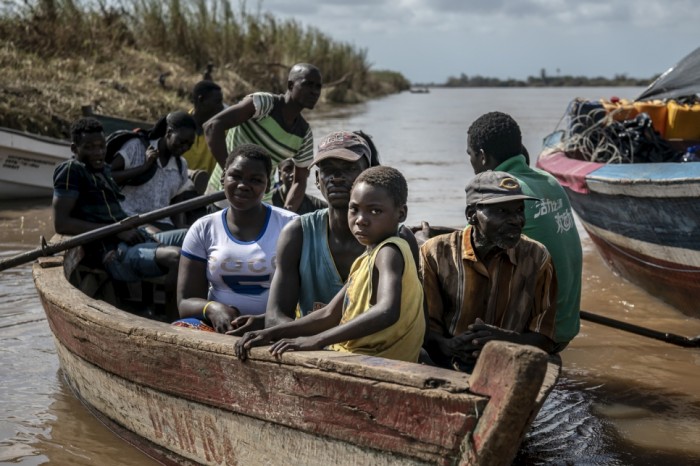 A small boat pulls into the Buzi dock carrying residents. Many people displaced from Buzi in the aftermath of Cyclone Idai are returning to check on the status of their homes and belongings.