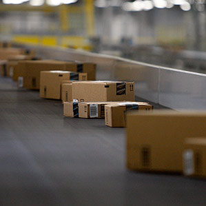 boxes travel along a conveyer in Amazon fulfillment center