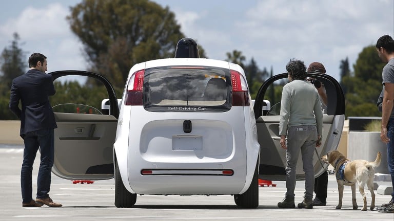 Passengers get into a self-driving car.