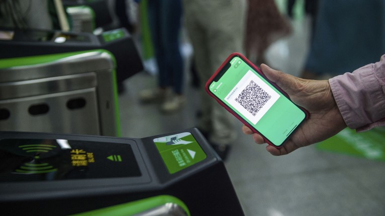 A transit rider uses their phone to pay a fare using WeChat pay.