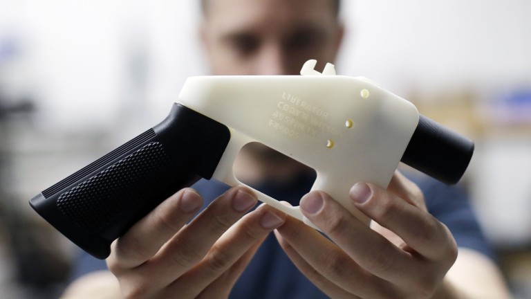 A man holding up a 3D printed gun