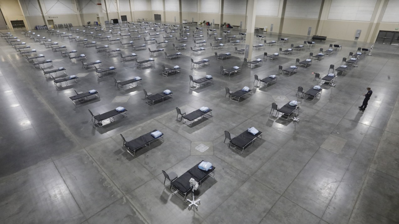 Rows and rows of hospital beds in a convention center, set up as an overflow room for non-coronavirus patients.