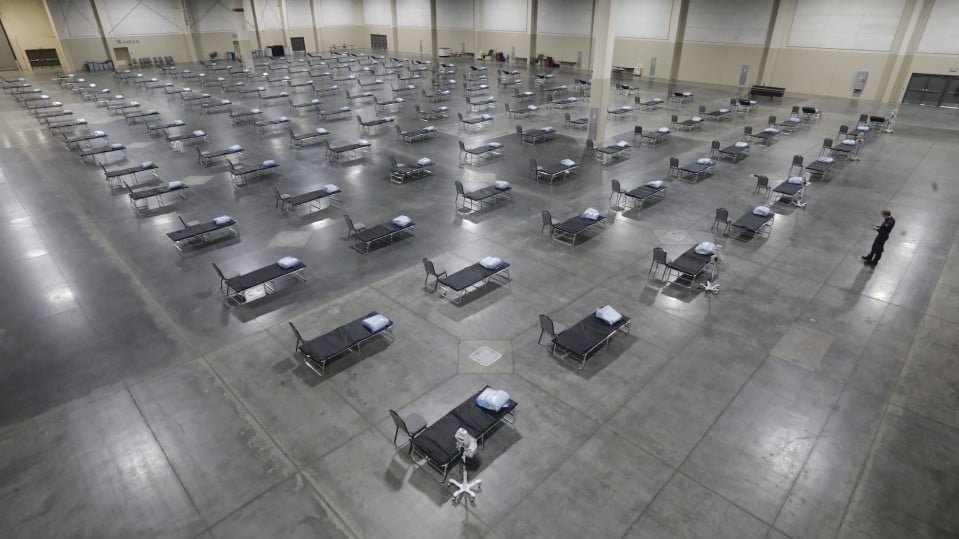 Rows and rows of hospital beds in a convention center, set up as an overflow room for non-coronavirus patients.