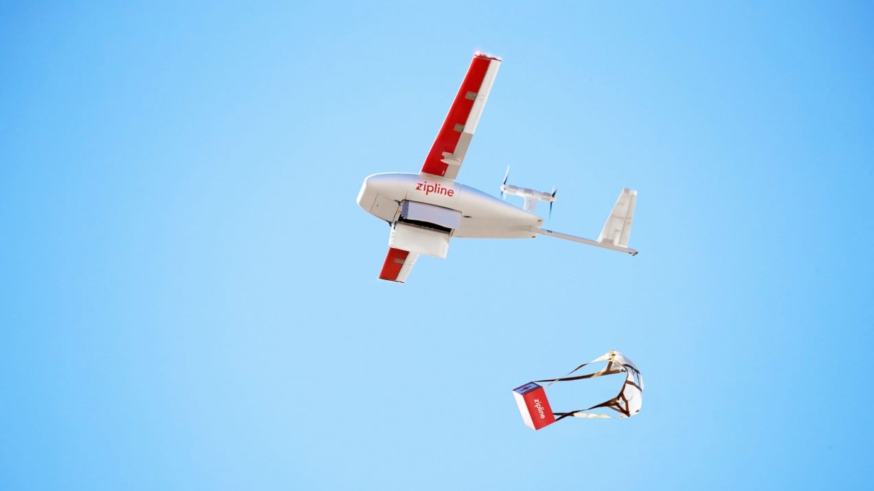 An image of a Zipline airplane dropping a parachuted box