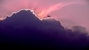 A plane flies near clouds.