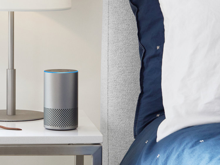 An Amazon Echo device beside a bed