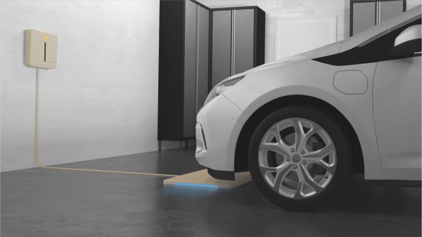 Rendering of cars on charging platforms in a home garage.