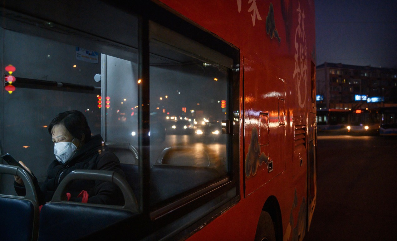 Beijing woman riding bus using mobile phone