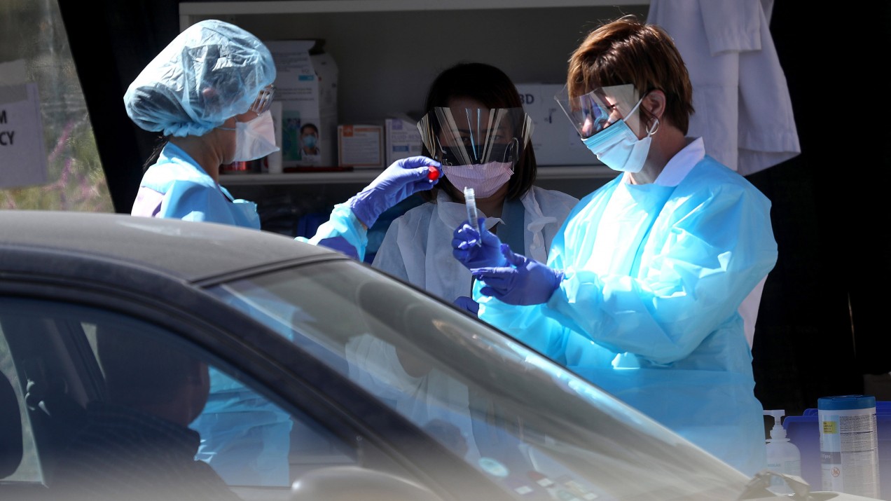 Medical personnel obtain samples from a drive-thru coronavirus testing station at a Kaiser Permanente facility in San Francisco.