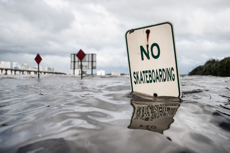 Photo of "No Skateboarding" sign partially covered in floodwater