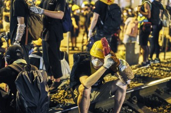 Protestors resting and waiting to decide what the next move will be at the West Rail Station in Yuen Long. 
The protestors are protesting the suspected collusion with Triads from last weeks Yuen Long West Rail station attacks on protestors and civilians.
 Yuen Long, New Territories, Hong Kong. July 27th, 2019.