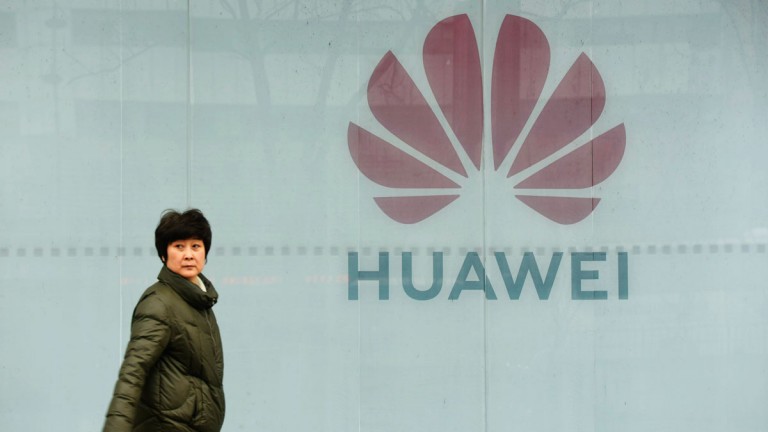A woman walks in front of Huawei store