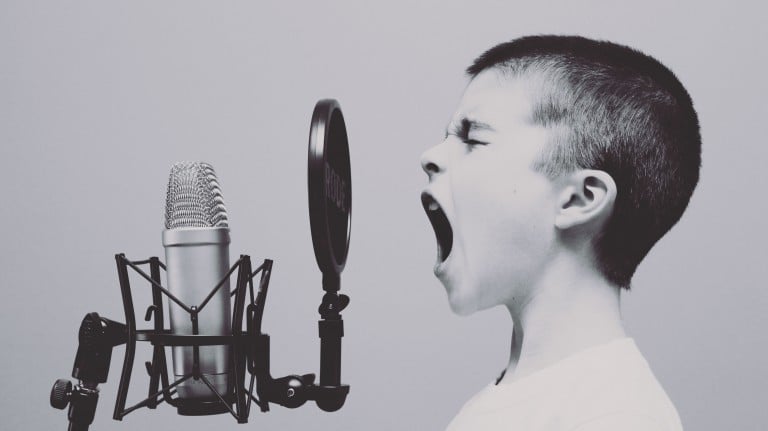 A boy screaming into microphone