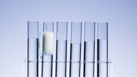 Photo of test tubes, one holding a tampon