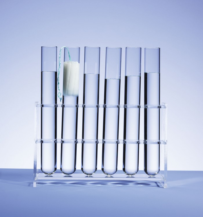Photo of test tubes, one holding a tampon