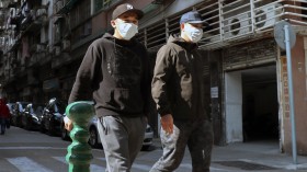 People walk on the street in Macau wearing face masks to protect themselves from coronavirus.