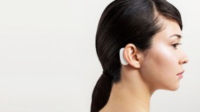 An image of a woman with a device behind her ear