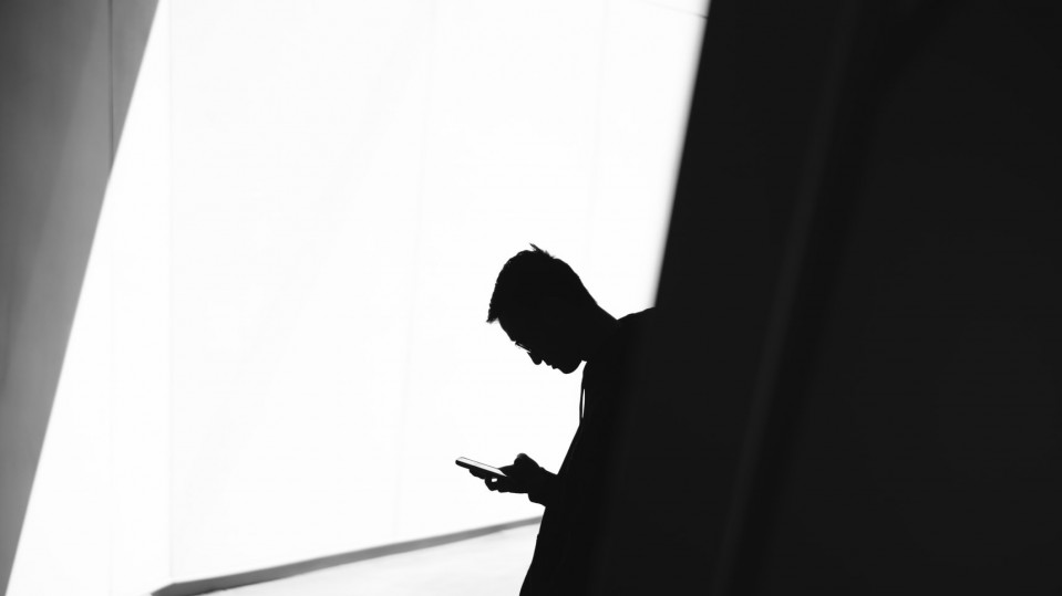 image of boy using phone in shadows black and white