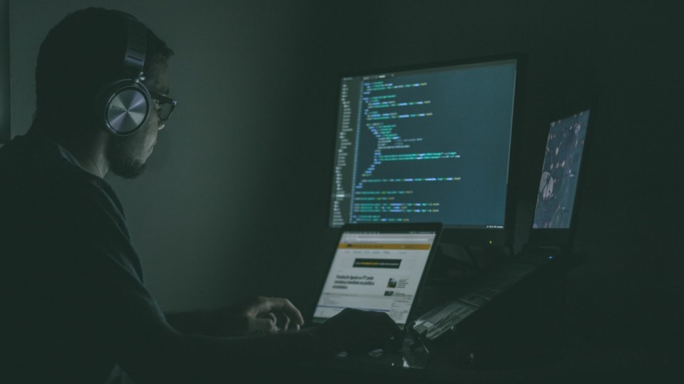 image of man looking at computer code three monitors automoderator automod moderating reddit