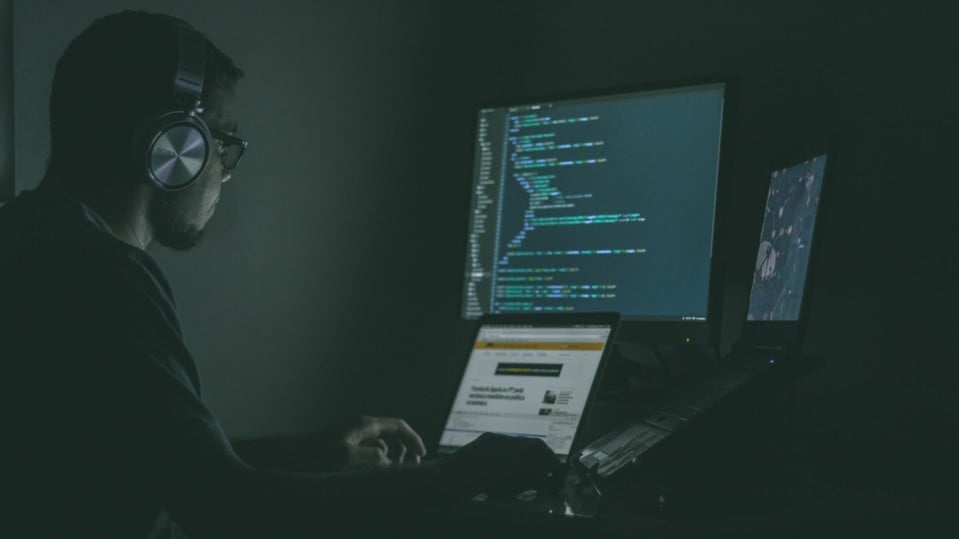 image of man looking at computer code three monitors automoderator automod moderating reddit