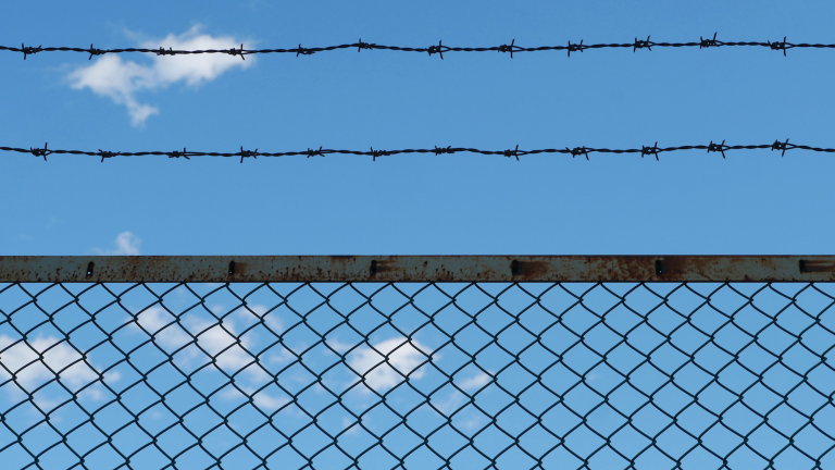 Prison fence with barbed wire