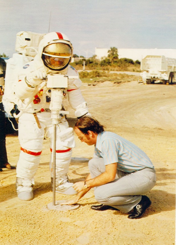 Photo of two men, one is wearing an astronaut suit