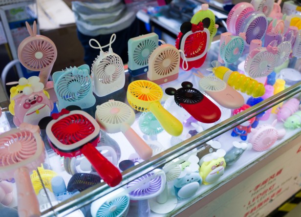 Photo of a vendor selling individual hand held fans of varying designs