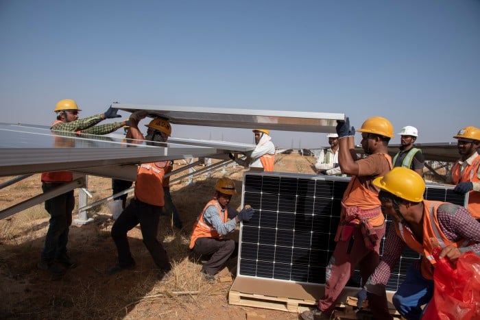 Photo of a group of men installing new solar panels