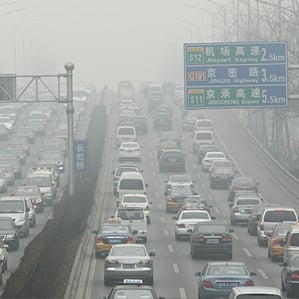 cars travel on a road in heavy smog in Beijing, China