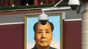 Photo of two surveillance cameras next to a portrait of Mao Zedong.