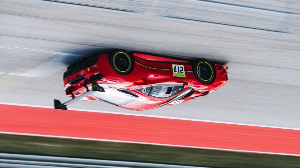 An image of a race-car on a track, rotated to appear upside-down.