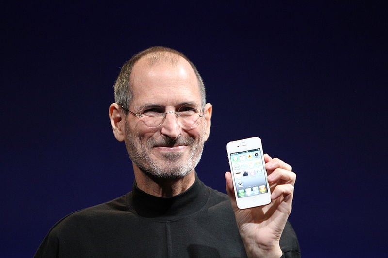 Steve Jobs holding white iPhone