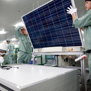 workers lift solar panel