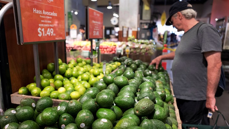A man shops for avocados in Whole Foods in New York